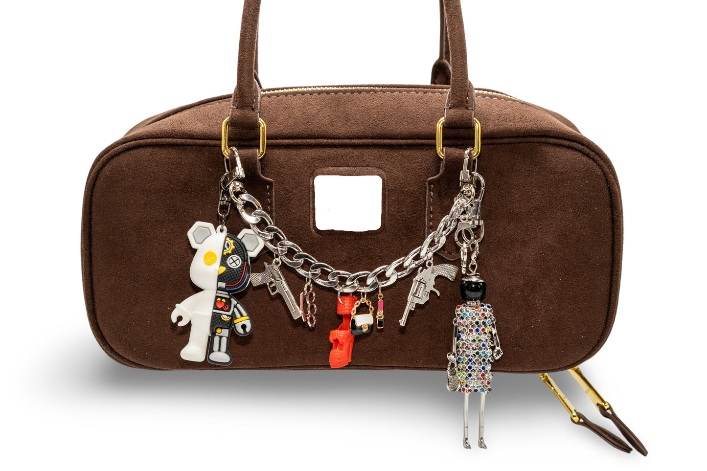 A brown handbag with custom-made chain charms attached to it. The charms include a small stuffed toy, a keychain, and other decorative items.